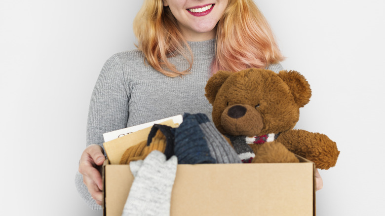 Woman holding box of items