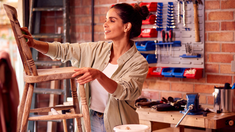 Woman upcycling wooden chair