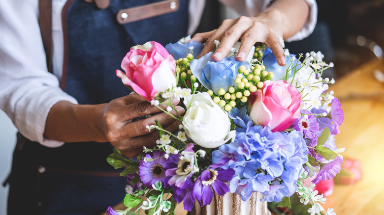 person arranging artificial flowers 