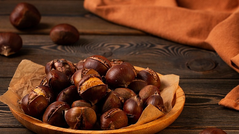 Shiny brown chestnuts on autumn leaves