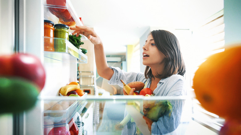 Woman rearranging fridge