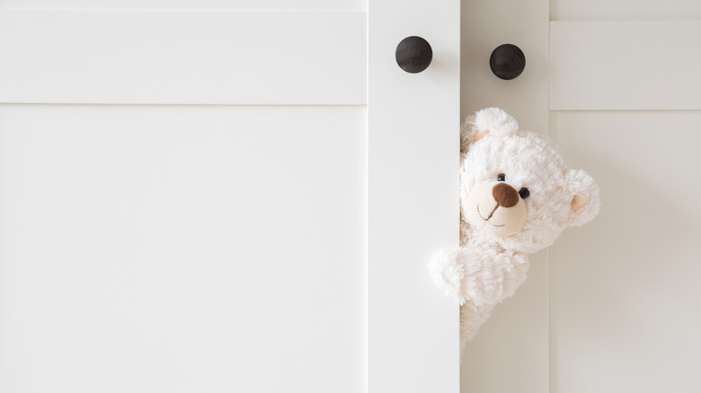 white teddy bear peeks out from child's bedroom closet doors before they get a functional upgrade