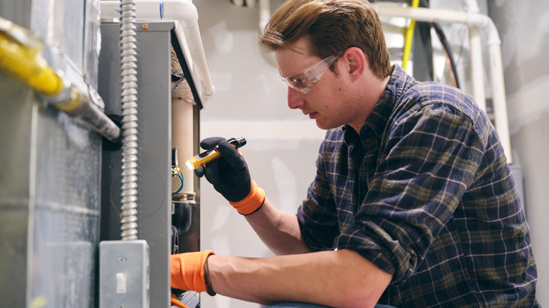 Man making repairs on a homeowner's furnace