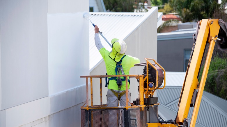 worker pours white paint