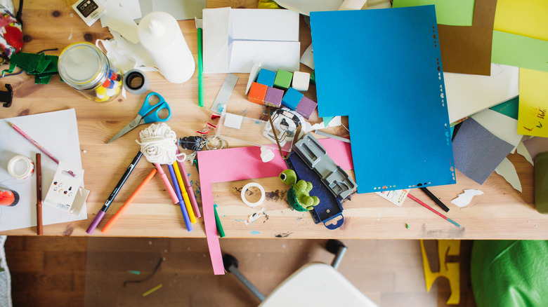 A messy table covered with craft supplies.