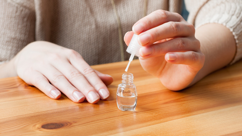 Person applying clear nail polish