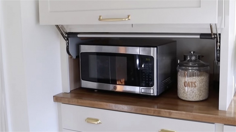 Microwave and oatmeal in cabinet