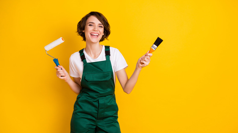 Woman with paint roller and brush