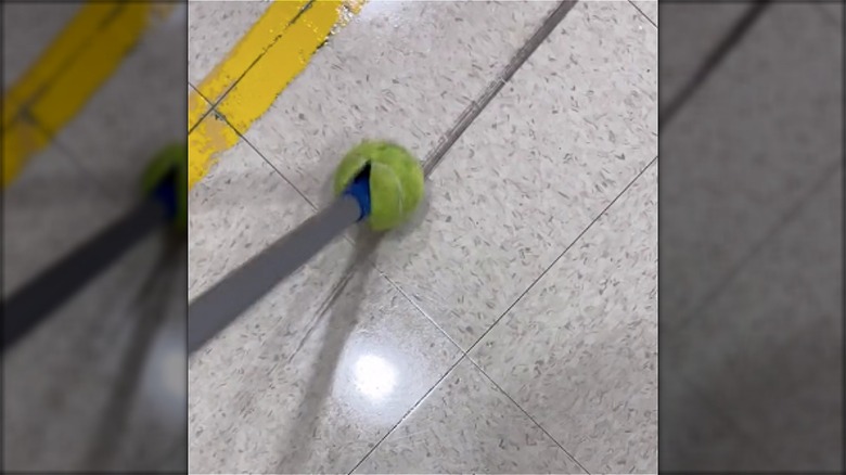 Cleaning floor with tennis ball