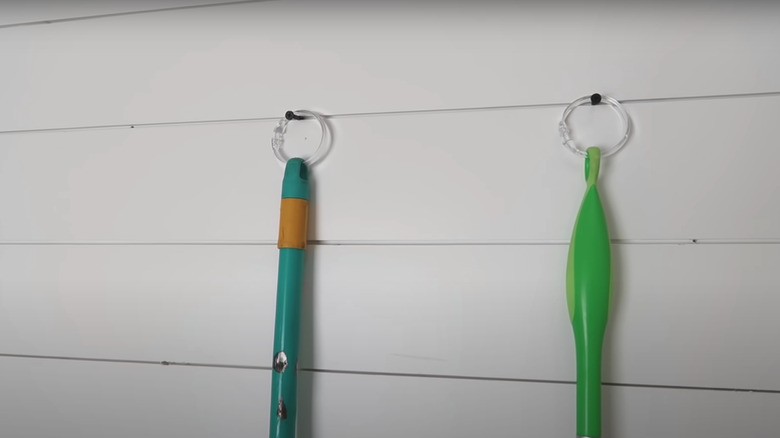 Swiffers hanging on wall with shower ring