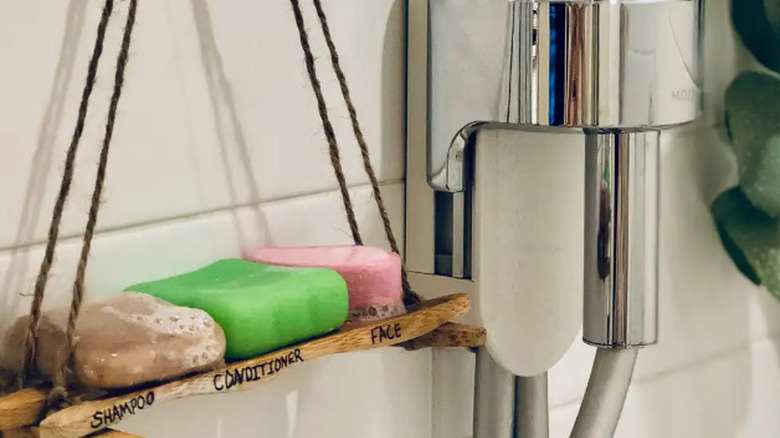 A hanging bathroom shelf crafted from bamboo toothbrushes, designed for the shower area.