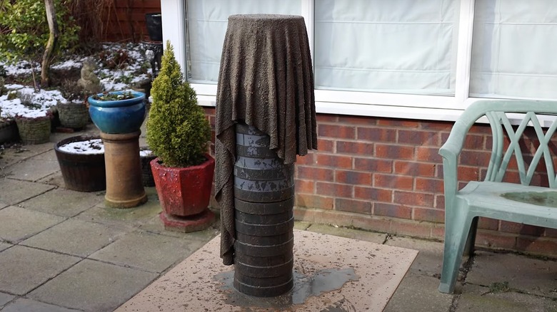 A towel soaked in concrete mix draped over a stack of buckets