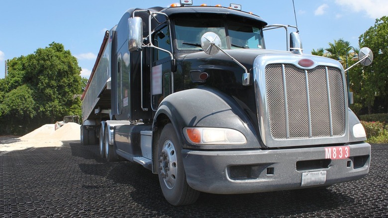 An 18-wheeler truck on top of a gravel drive grid system