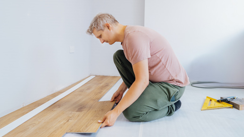 Man fitting vinyl floor planks