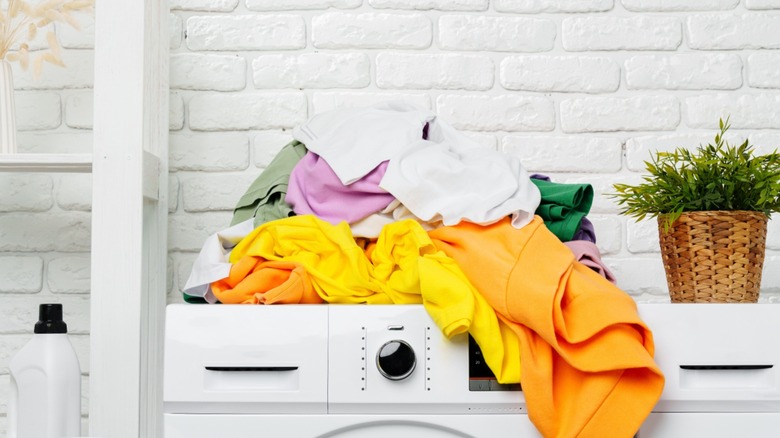 Washing machine with a pile of clothes on top