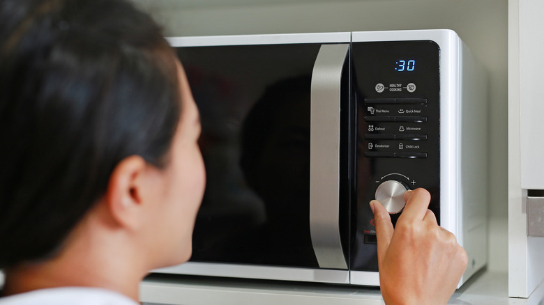 Person turning microwave dial