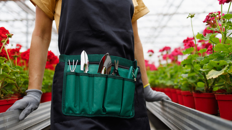 person wearing green gardening belt