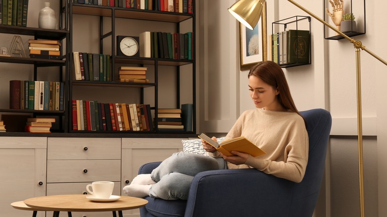 Woman reading book on chair