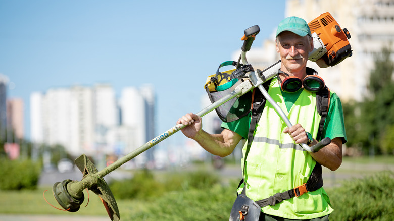 man holding a weed trimmer