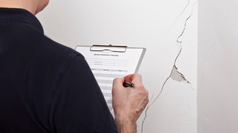 engineer looking at cracked wall