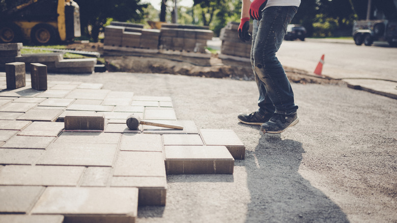 A person is laying pavers