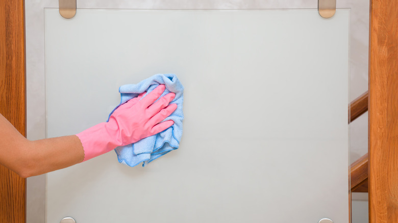 person cleaning glass