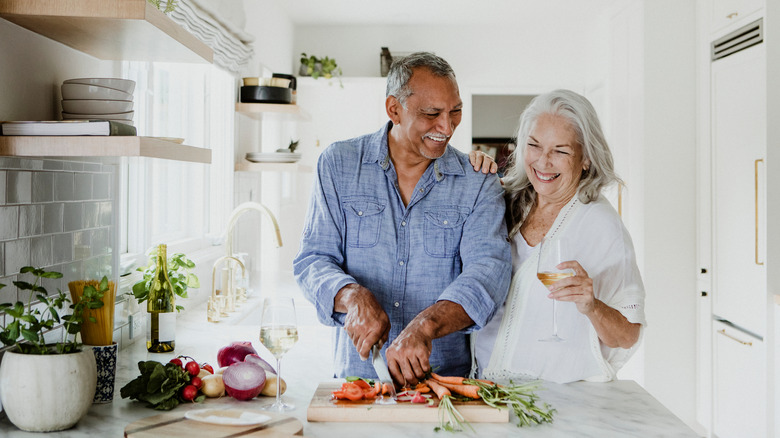 senior couple cooking in kitchen