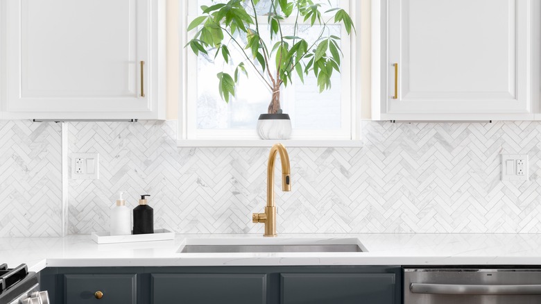 Kitchen sink area with gold faucet