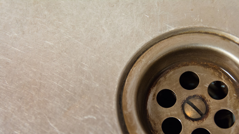 Closeup scuffed steel sink drain 