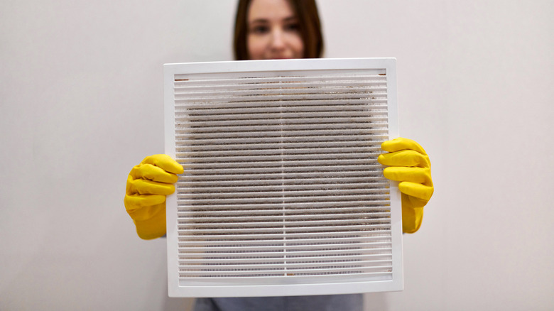 woman holding dust filled filter