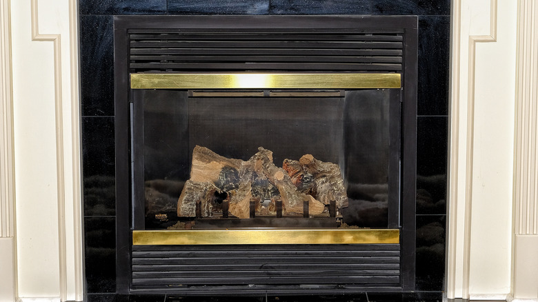 brass fireplace with logs inside