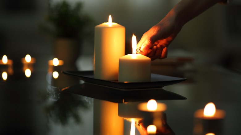 person lighting candles in room