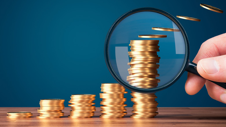 stacked coins with magnifying glass