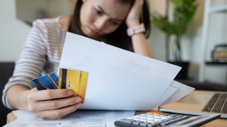 Distressed woman examines bill