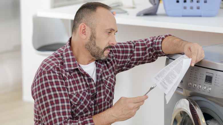 person installing washer with wrench