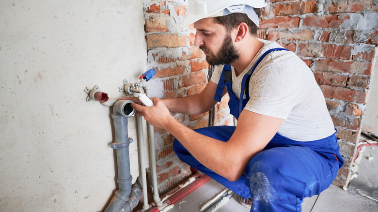 Plumber working on pipes