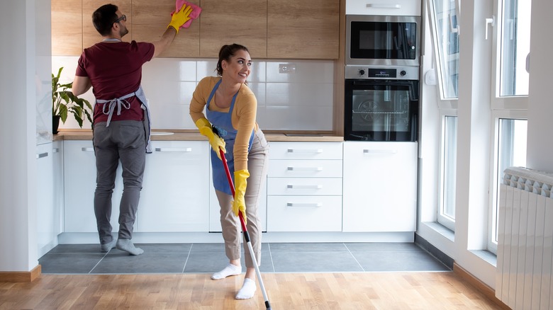 Two people dusting and sweeping