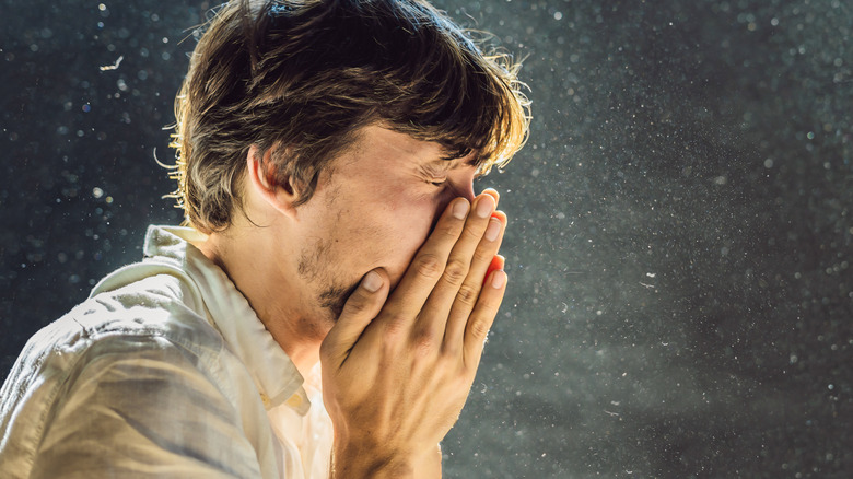 Man sneezing in dust