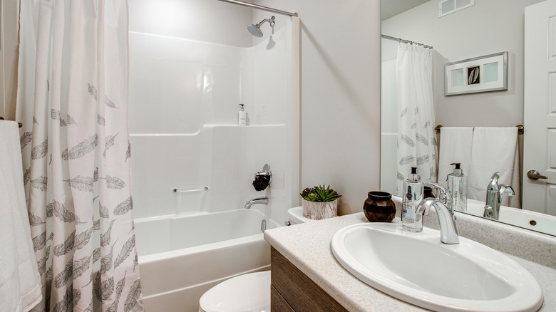 White-walled shower and tub combo set in a small bathroom