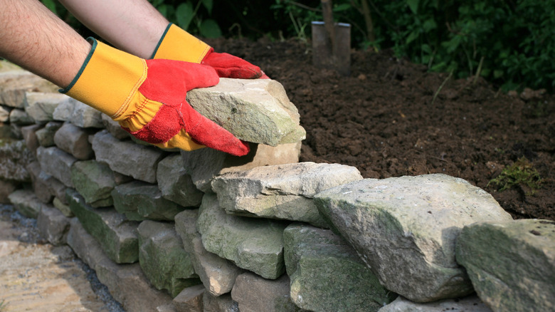 man building stone garden wall