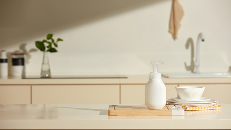 Modern scullery layout with sink, dishes, storage cabinets, and prep materials