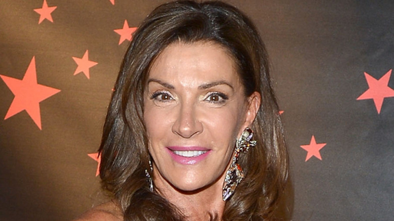 Hilary Farr smiling in front of red carpet backdrop