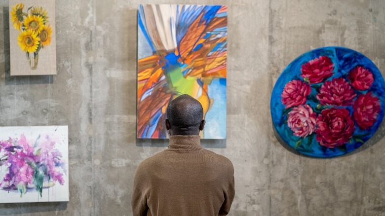 Man looking at art on wall