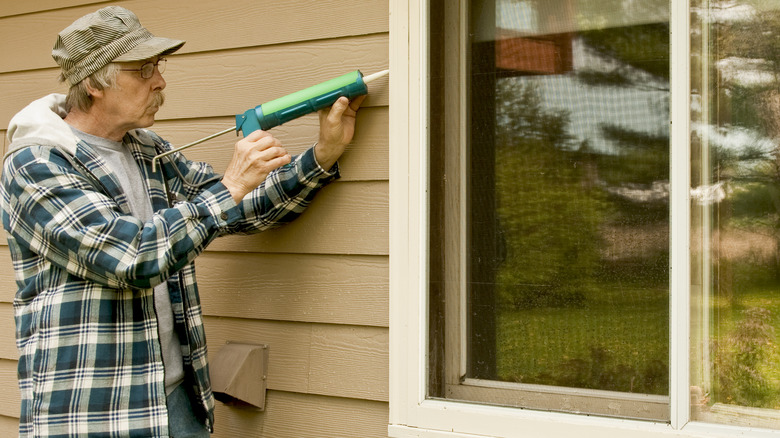 Man caulking window