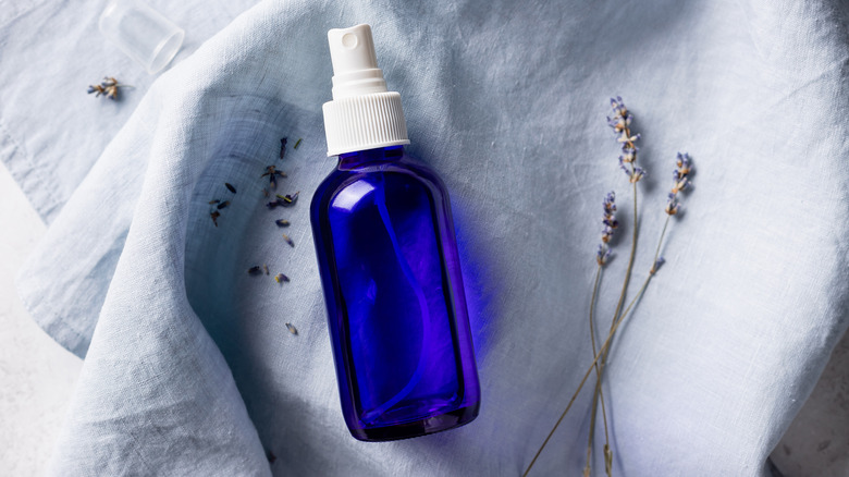 Blue spray bottle and lavender on fabric