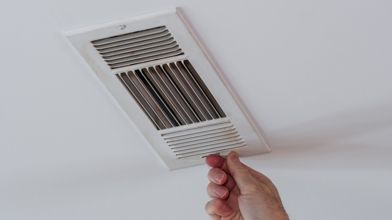 Hand adjusts air vent