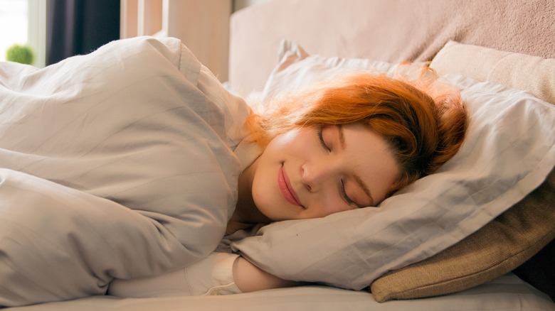 Red-headed woman asleep in bed