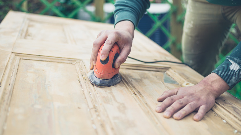 A person sanding a door