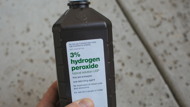 Holding a bottle of hydrogen peroxide