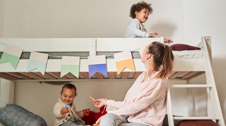 A mother and two children on a bunk bed